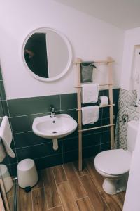 a bathroom with a sink and a toilet and a mirror at X Rooms in Našice