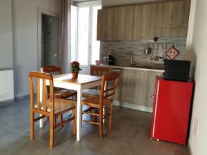 een keuken met een tafel met stoelen en een rode koelkast bij Locazione turistica da Enzo e Maria in Ragusa