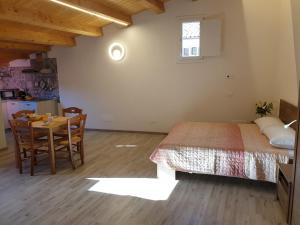 1 dormitorio con 1 cama, mesa y sillas en Locazione turistica da Enzo e Maria, en Ragusa