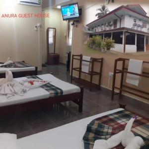 una camera con due letti e una tv e una casa di Anura Guest Inn a Ella
