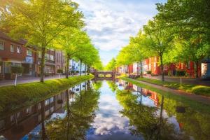 un canal en medio de una ciudad con árboles en Parkhotel Papenburg, en Papenburg