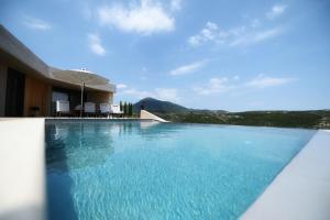Blooms of Sivota Bay - Luxury villas with private heated pool في سيفوتا: مسبح مطل على جبل