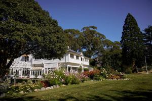a white house with a garden in front of it at Kaituna Valley Homestead in Little River