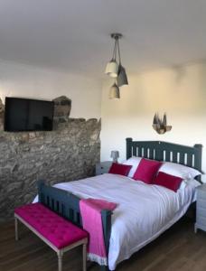 a bedroom with a large bed and a tv on a wall at Raymond House B&B Penally, Tenby in Penally