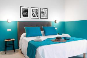 Una cama con paredes azules y un sombrero. en Sorrento Colors&Suites, en Sorrento