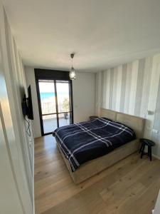 a bedroom with a bed and a large window at Bat Galim Luxury balcony SEA view Nearby The Beach for Doctor's in Haifa