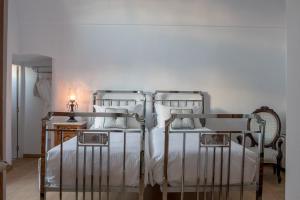 - une chambre avec 2 lits et des draps blancs dans l'établissement Casasantantonio 18th Century Luxury Mansion, à Fira
