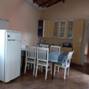 La cuisine est équipée d'une table, de chaises et d'un réfrigérateur. dans l'établissement Recanto Flor de lis, à Gonçalves