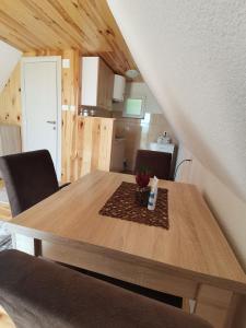 Village Cottage في زبلجك: طاولة طعام خشبية مع كراسي في الغرفة