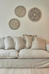 a couch sitting in a living room with plates on the wall at La Cigogne Boutique Suites in Retranchement