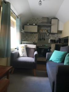 a living room with a couch and a chair at Delighful self catering in the heart of Glastonbury in Glastonbury