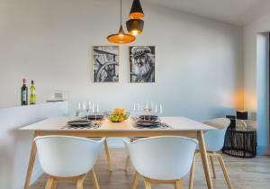 a dining room with a table and white chairs at Captain's Home Heiligenhafen in Heiligenhafen