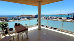 balkon ze stołem i widokiem na port w obiekcie Amazing ocean view apartment w Corralejo