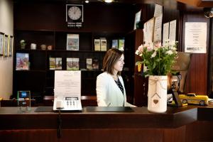 a woman standing at a cash register in a store at Parkhotel Papenburg in Papenburg