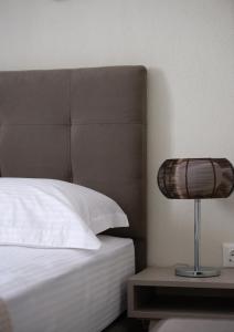 ein Schlafzimmer mit einem Bett und einer Lampe auf einem Tisch in der Unterkunft Crist Luxury Apartments in Nea Potidaea