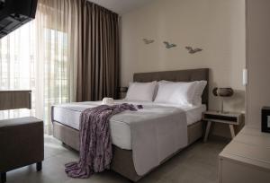 Un dormitorio con una cama grande y una ventana en Crist Luxury Apartments, en Nea Potidaea