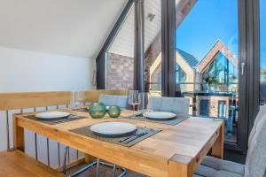 a dining room with a wooden table and a large window at Fischerdorf Hafenloft (mit Meerblick) in Heiligenhafen