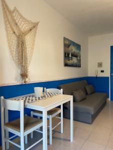 ein Wohnzimmer mit einem Tisch und einem Sofa in der Unterkunft RodiMare in Rodi Garganico