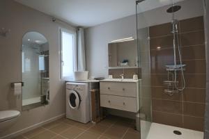 łazienka z umywalką i pralką w obiekcie La Petite Montille w mieście Mont-Dore