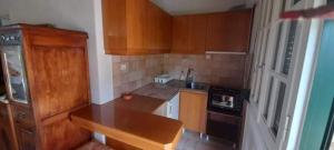 a small kitchen with wooden cabinets and a stove at SOILE GEORGIA-HOUSE in Loutra Edipsou