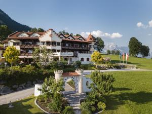 ein großes Gebäude auf einem Hügel mit Garten in der Unterkunft Hotel AlpenSchlössl in Söll