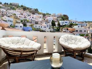 two chairs and a table on a balcony with a view at Lion House I in Ioulis