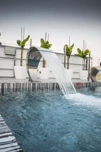 a water slide in a pool with potted plants at Glaros Royal Beach Hotel in Hersonissos