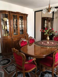 a dining room with a glass table and red chairs at Apartament Maria in Supraśl