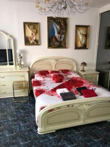 a bedroom with a large bed with red flowers on it at Apartament Maria in Supraśl