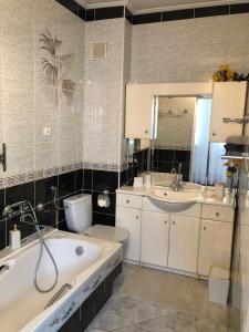 e bagno con vasca, servizi igienici e lavandino. di Apartament Maria a Supraśl