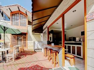 an outdoor kitchen with wooden stools and a table at Capital O 90497 Navaya Guest House in Banyumas