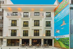 a large white building with tables in front of it at Barbera Hotel in Istanbul