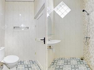 a bathroom with a shower and a toilet and a sink at Capital O 90497 Navaya Guest House in Banyumas