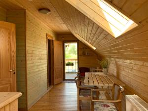 a wooden room with a table and a skylight at Lubāna mitrāja informācijas centrs in Abaine