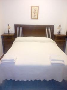 1 dormitorio con 1 cama blanca grande y 2 mesitas de noche en Casa Rural del Médico I y II, en Herradón de Pinares