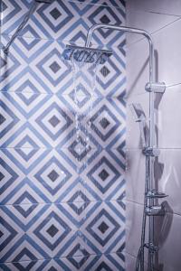 eine Dusche im Bad mit blauen und weißen Fliesen in der Unterkunft OLEA Luxury Apartments in Parga + 79 Fotos