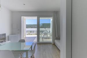 a living room with a table and a view of the ocean at Capo Falcone Charming Apartments in Stintino