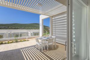a patio with a table and chairs on a balcony at Capo Falcone Charming Apartments in Stintino