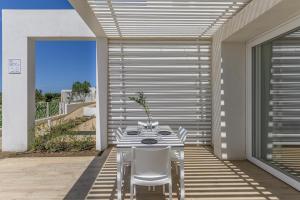 a patio with a table and chairs on a porch at Capo Falcone Charming Apartments in Stintino