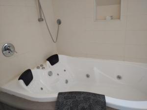 a white bath tub sitting in a bathroom at צימר ארבלית - ליד טבריה ו כנרת בגליל ב ארבל in Arbel