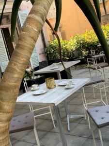 a white table and chairs and a palm tree at Le 5 Vie in Bergamo