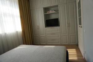 a bedroom with a bed and a flat screen tv at Heart of Vilnius Apartment in Vilnius