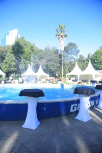 a swimming pool with two stools in front of a fountain at GHION HOTEL in Addis Ababa