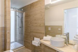 a bathroom with a white sink and a shower at Capo Falcone Charming Apartments in Stintino