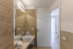 a bathroom with two sinks and wooden walls at Capo Falcone Charming Apartments in Stintino