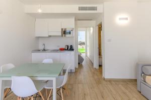 a kitchen and dining room with a table and chairs at Capo Falcone Charming Apartments in Stintino