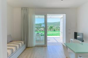 a bedroom with a bed and a sliding glass door at Capo Falcone Charming Apartments in Stintino