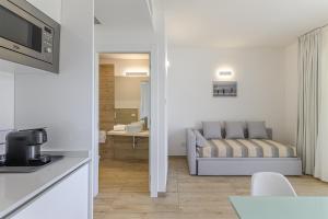 a kitchen and a living room with a couch at Capo Falcone Charming Apartments in Stintino