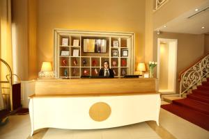 a woman standing behind a counter in a hotel lobby at Palace Hotel & SPA in Durrës
