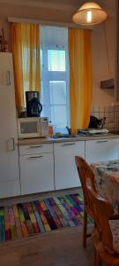 a kitchen with a microwave and a table and a window at Da Tizzi in Deutschlandsberg